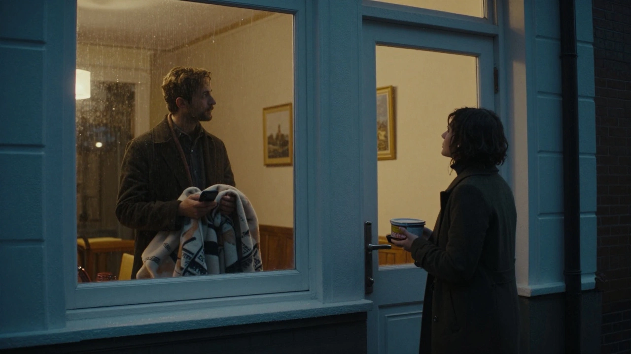 A person stands alone in the rain as their partner watches from a window, holding soup and a blanket.